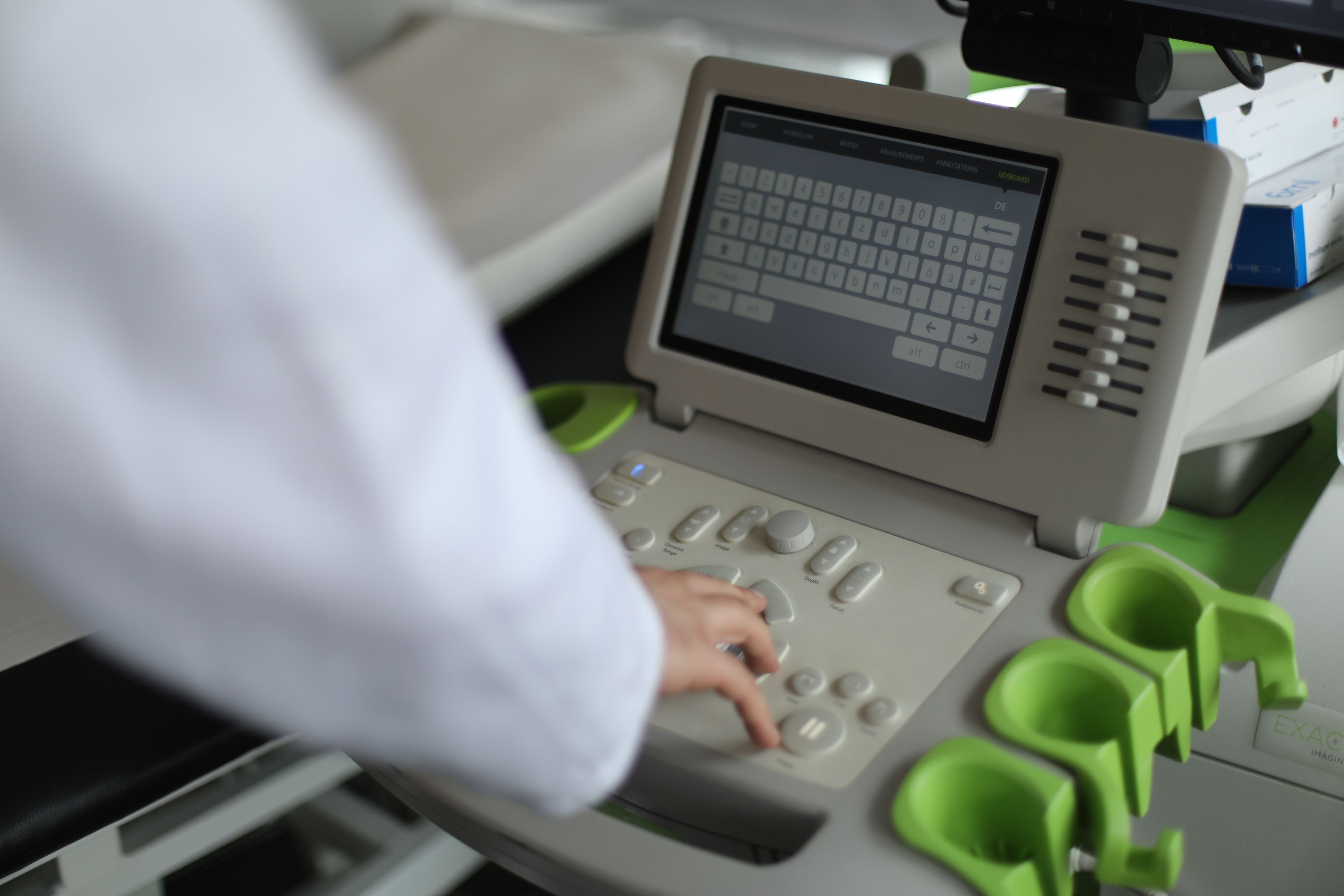 Hand bedient das Tastenfeld der Ultraschall-Konsole während einer Untersuchung