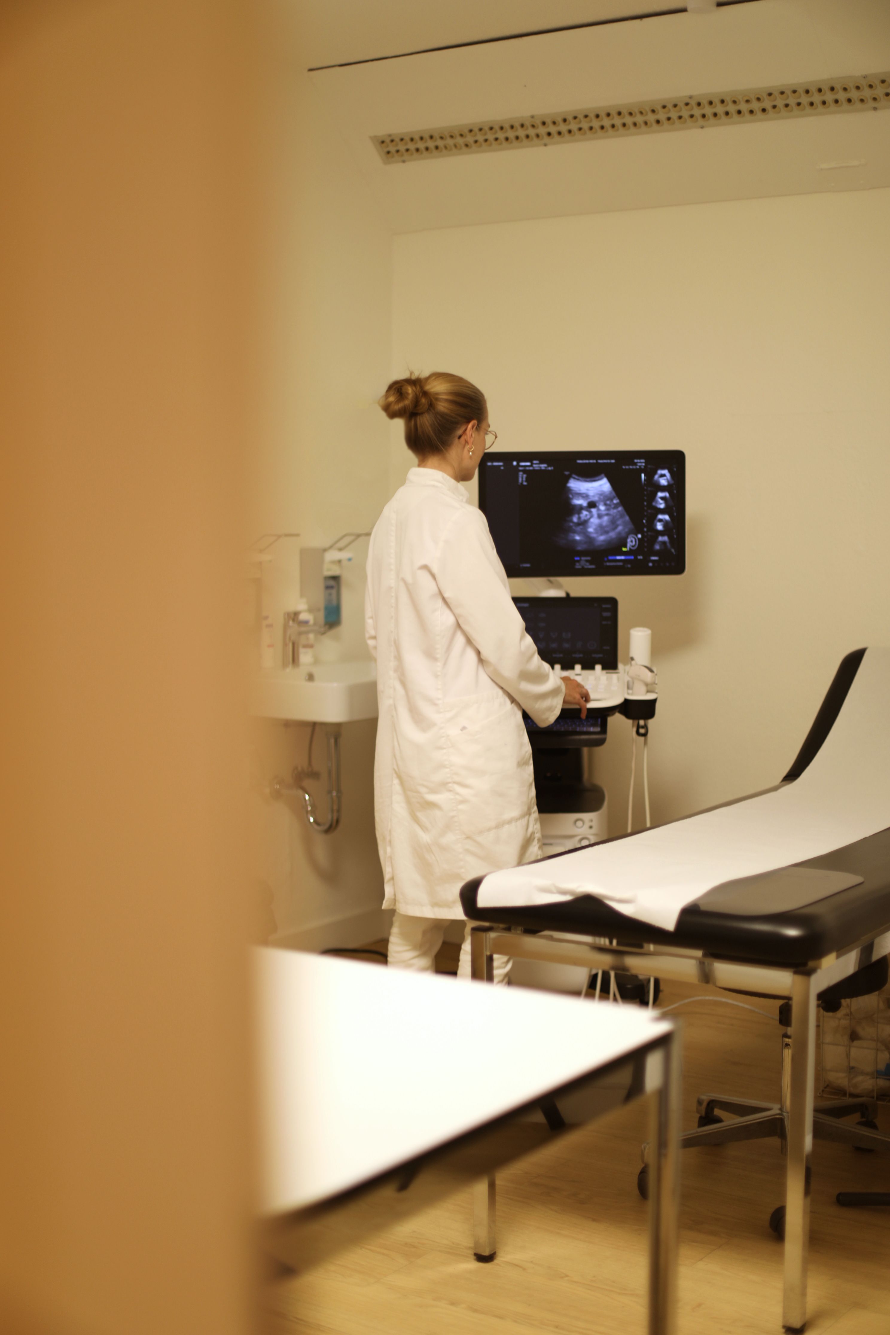 Ärztin betrachtet ein Ultraschallbild am Monitor im Untersuchungsraum