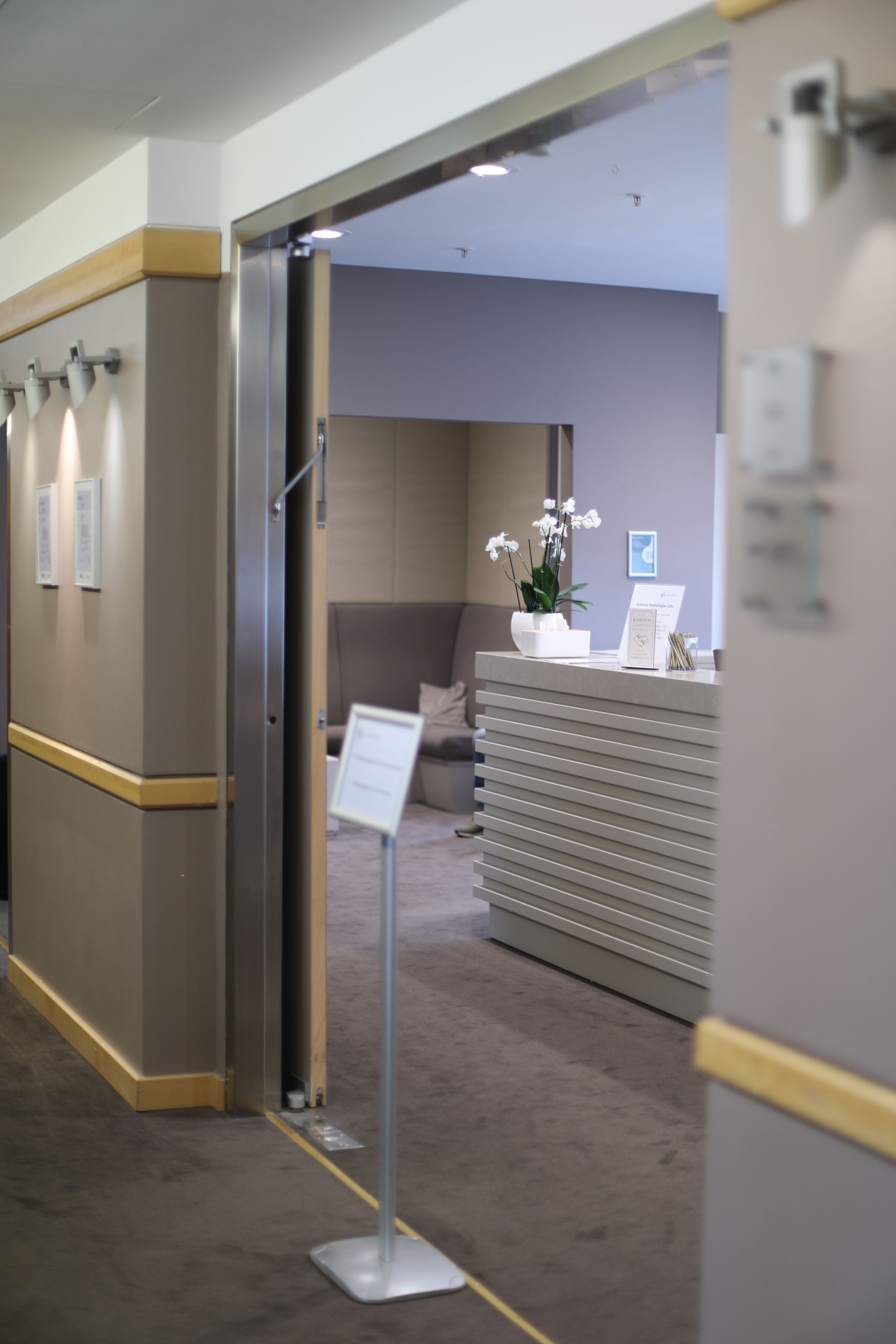 	Empfangsbereich des Standorts Meoclinic mit Orchidee auf dem Tresen